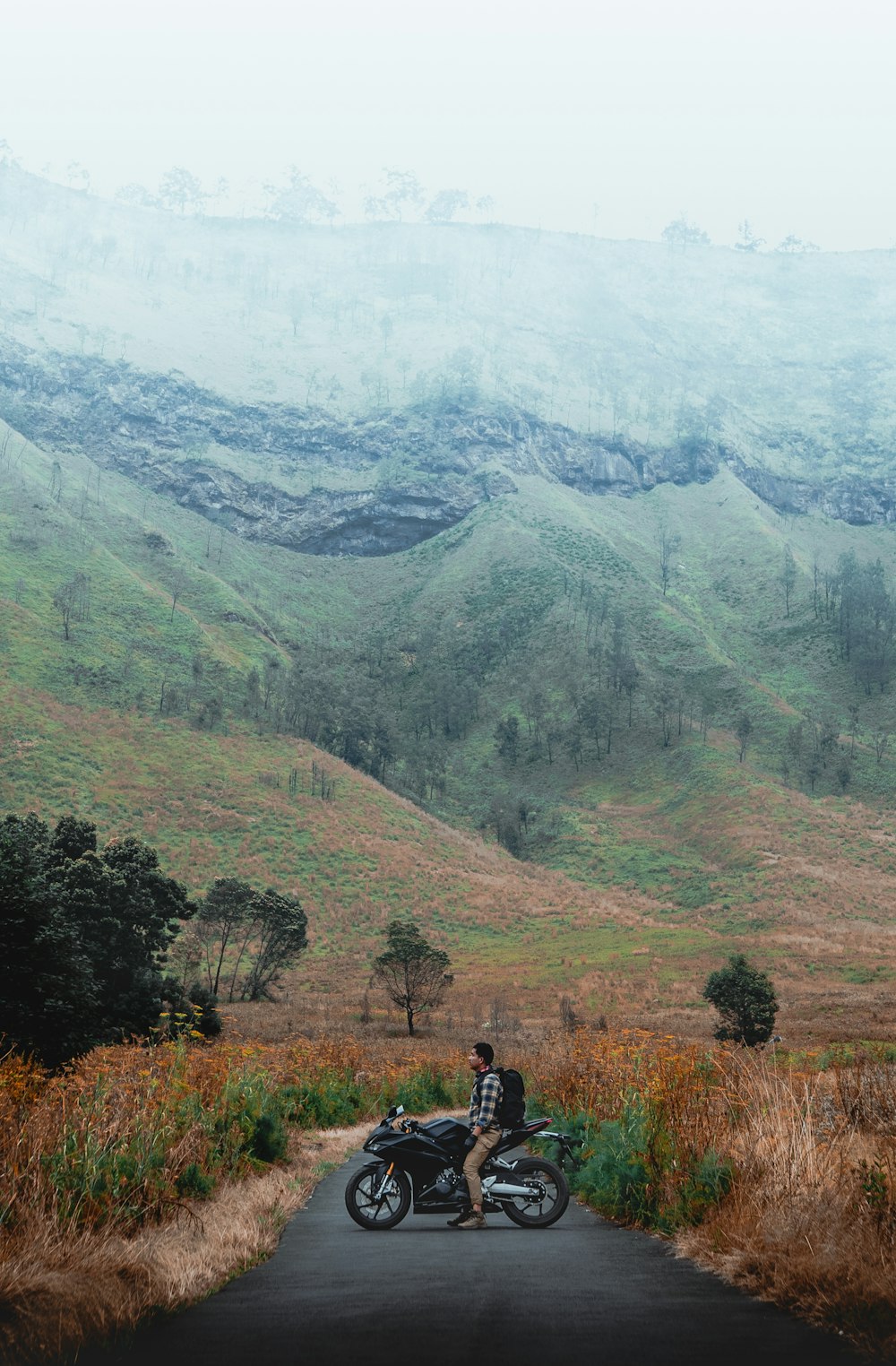 man riding on motorcycle near mountain