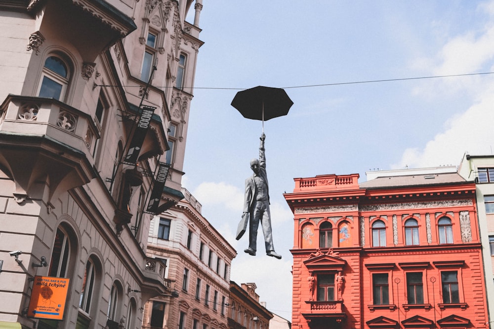 homem no terno segurando a estátua do guarda-chuva