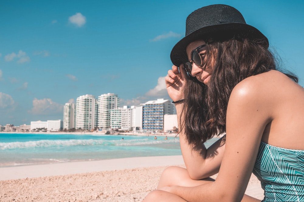 mulher sentada na praia durante o dia