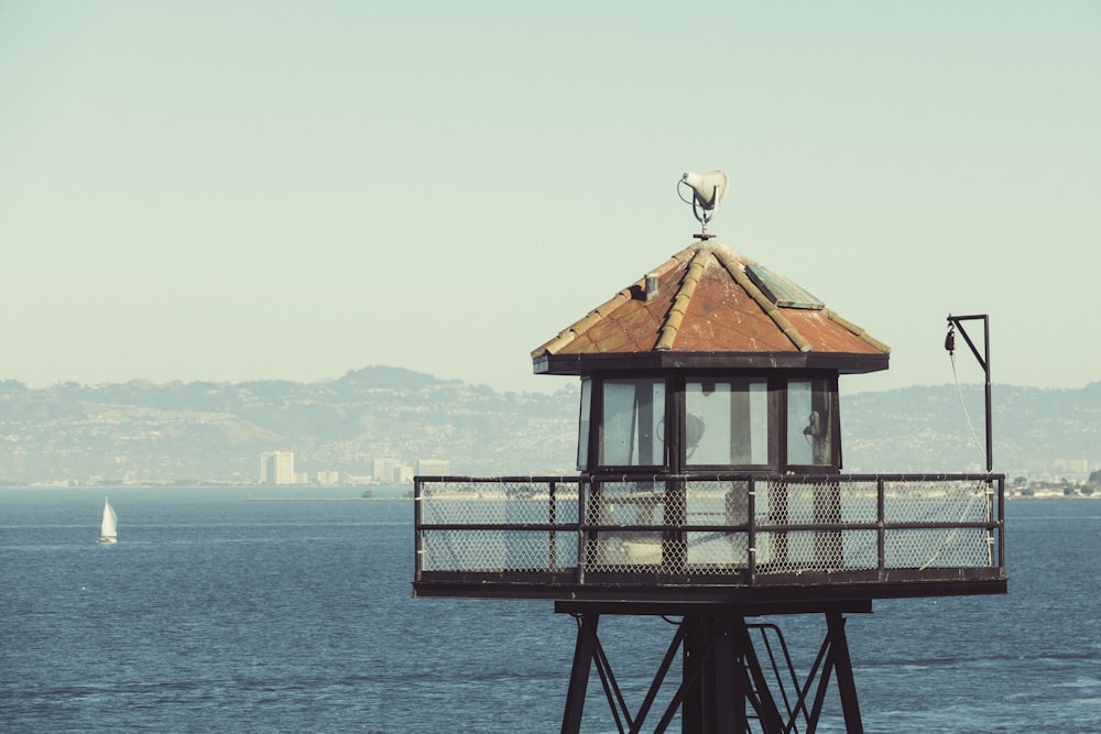 brown wooden watch tower near body of water under white sky