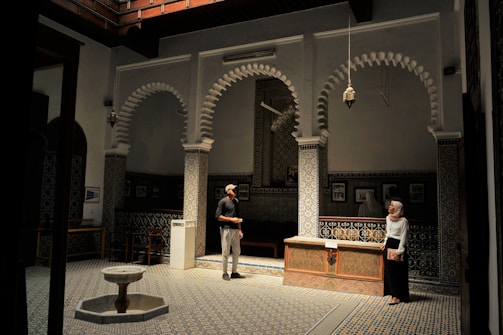 Researchers discussing findings in a serene study room with Islamic geometric patterns.