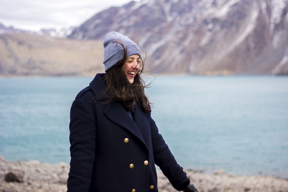 woman wearing coat near shore