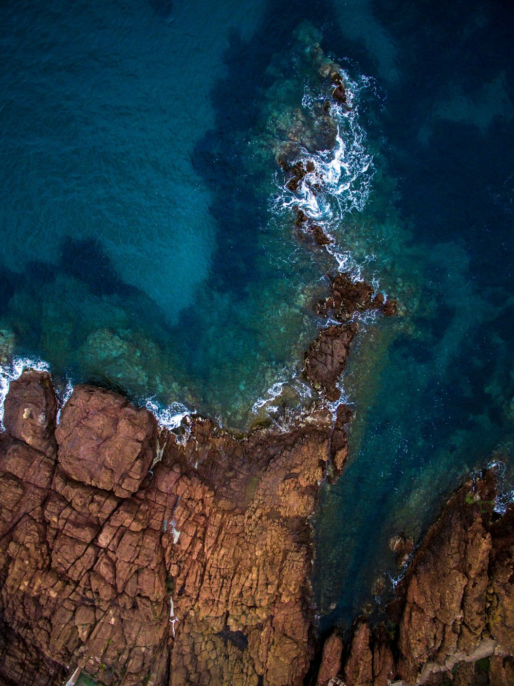 Vista aérea del mar en calma cerca de la formación rocosa