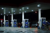 person taking a photo of blue and white gasoline station