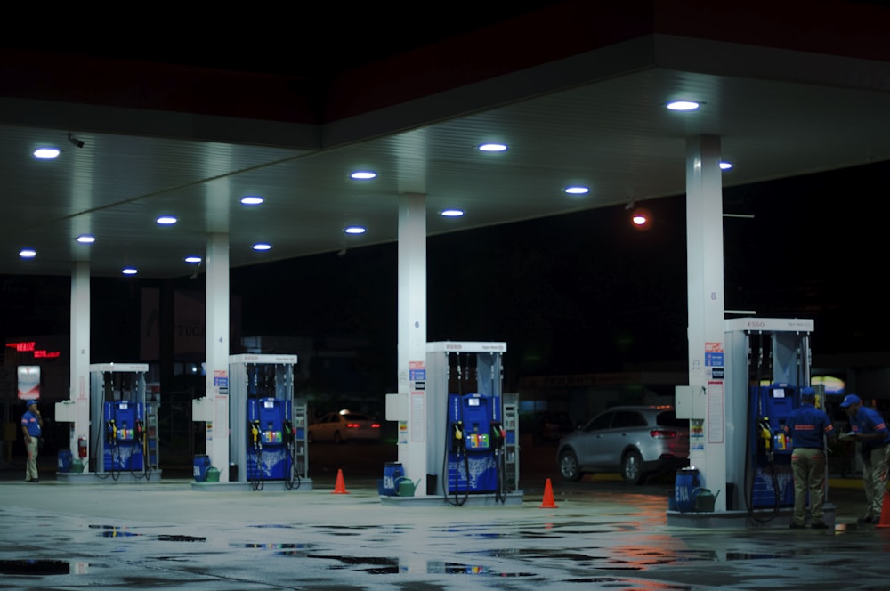 person taking a photo of blue and white gasoline station