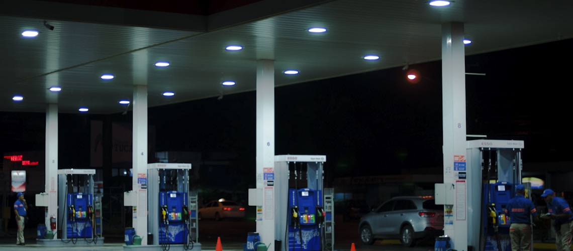 person taking a photo of blue and white gasoline station