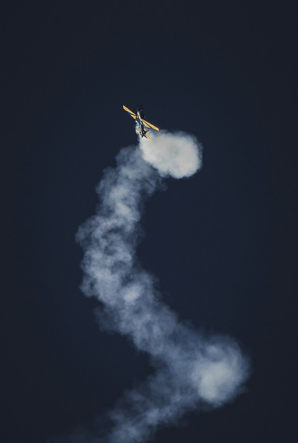 yellow and blue airplane on sky