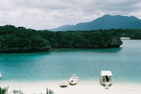 three boat on body of water in Kabira bay Japan