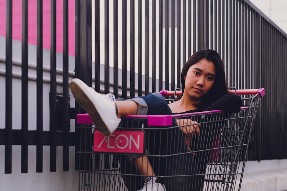 mulher sentada dentro do carrinho de compras