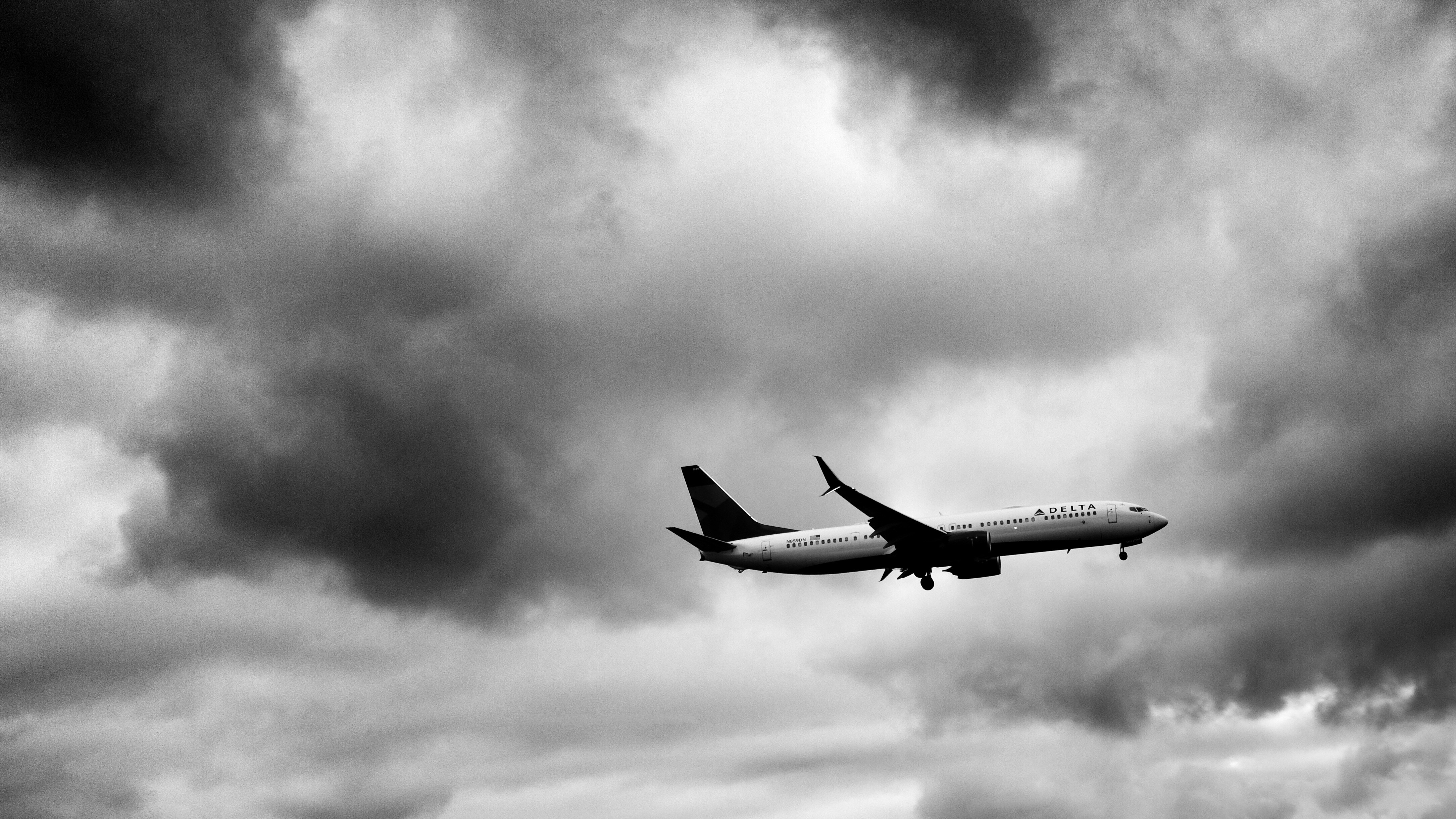 grayscale photo of airplane, Just finished dropping off a loved one at the airport and decided to test out my new camera. After this shot airport security came and asked me to move along. Cool cloud day too.