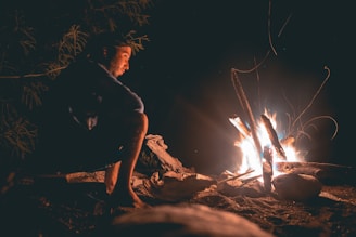 man seating beside fire