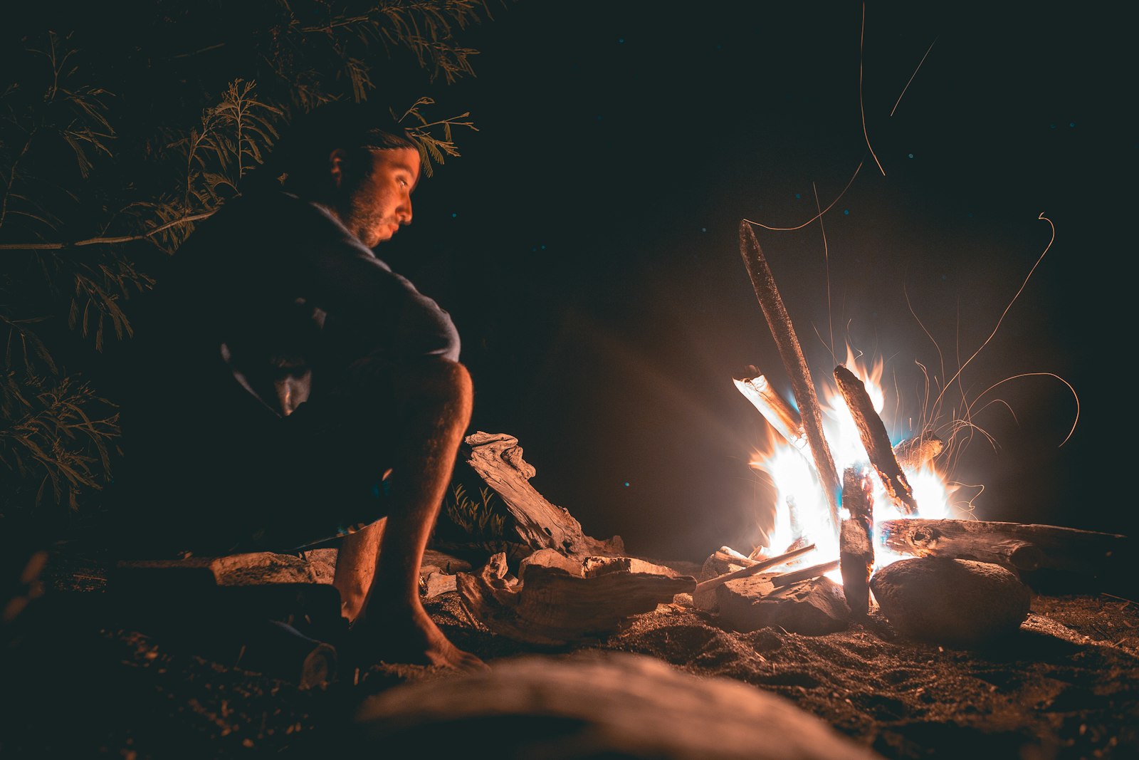 Canon EF 28mm F1.8 USM sample photo. Man seating beside fire photography