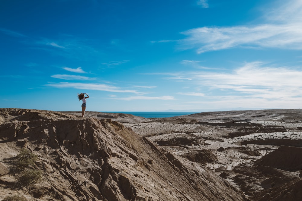 woman standing on fault block mountain during daytime