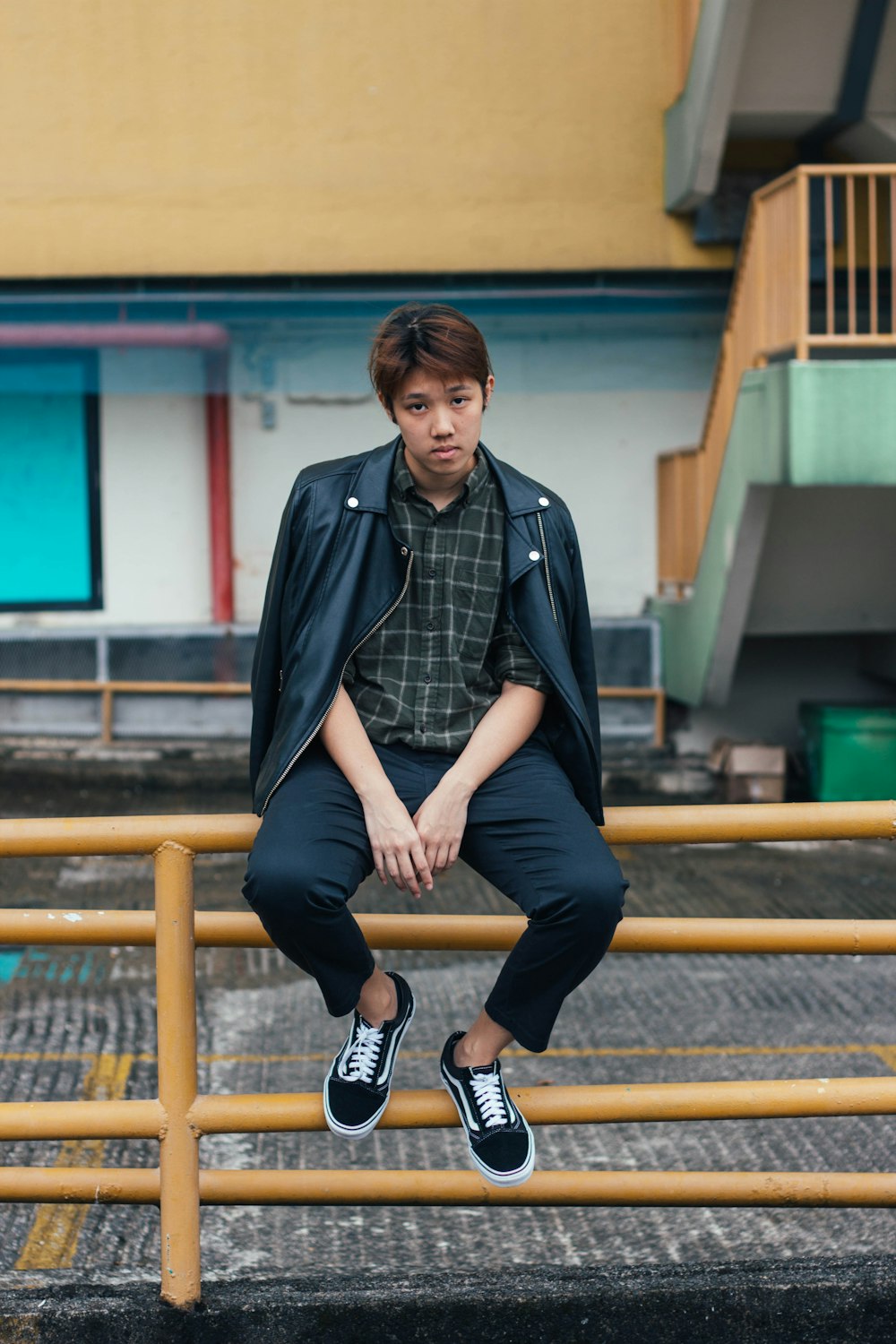 man sitting on yellow railing