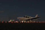 Ground crew preparing a small aircraft for a night flight.
