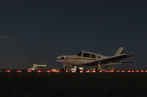 Ground crew preparing a small aircraft for a night flight.
