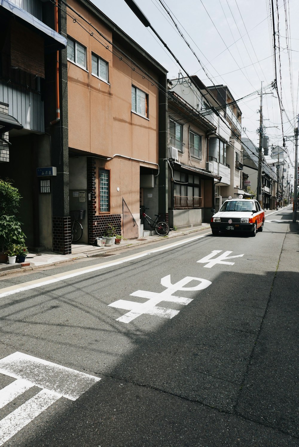 灰色の家の横の白い車