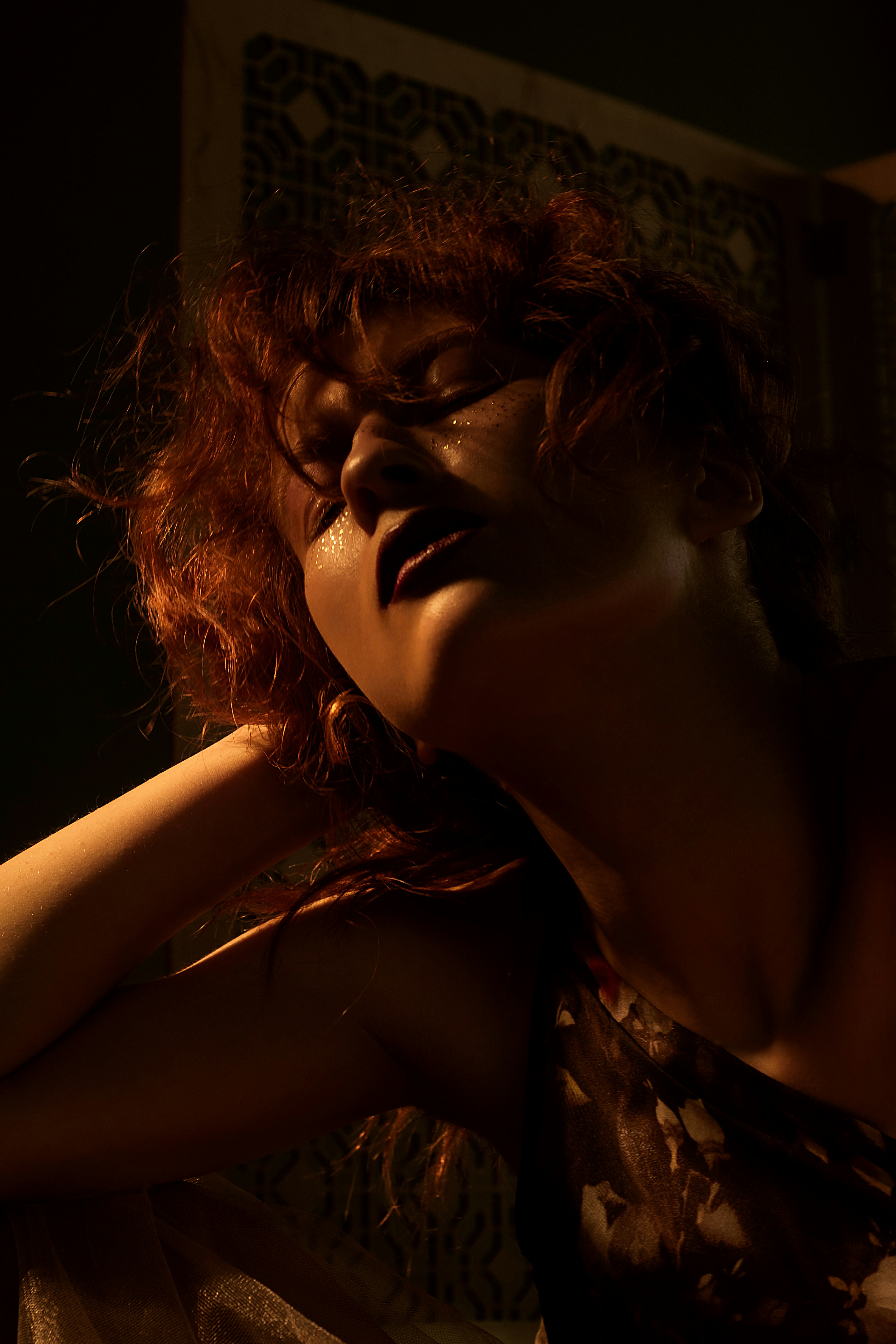Young woman with glamorous evening makeup, sparkle eyeshadow, warm studio lighting