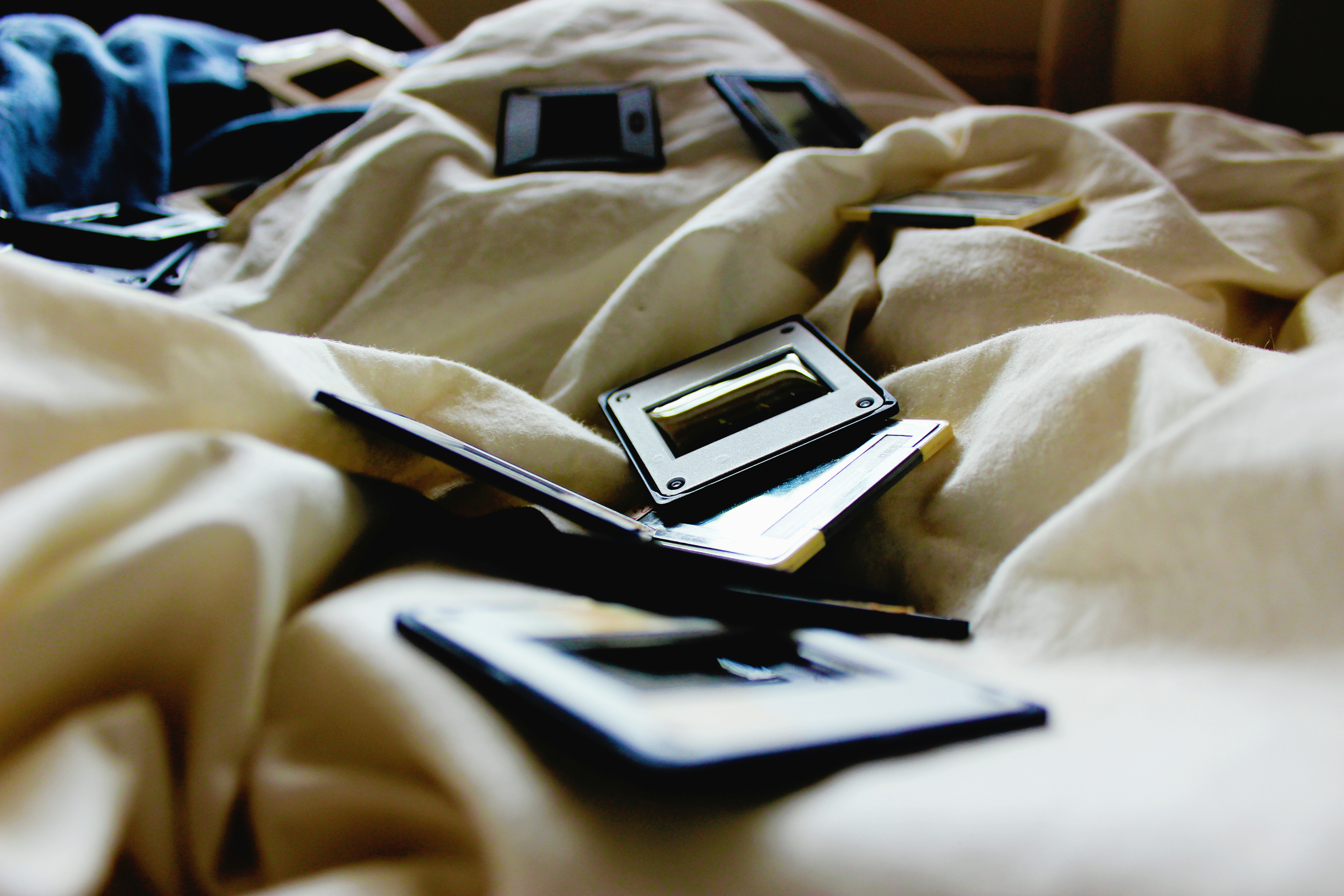 black and brown plastic cases on bed inside room sheet teams background