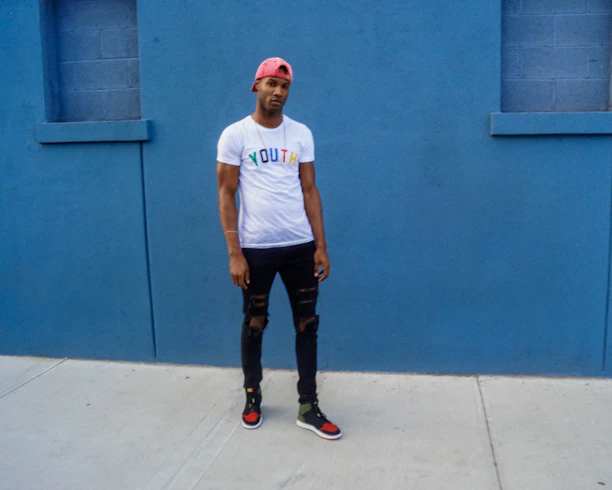 A stylish young person wearing a 43 d'etat graphic t-shirt against a minimalist urban backdrop.