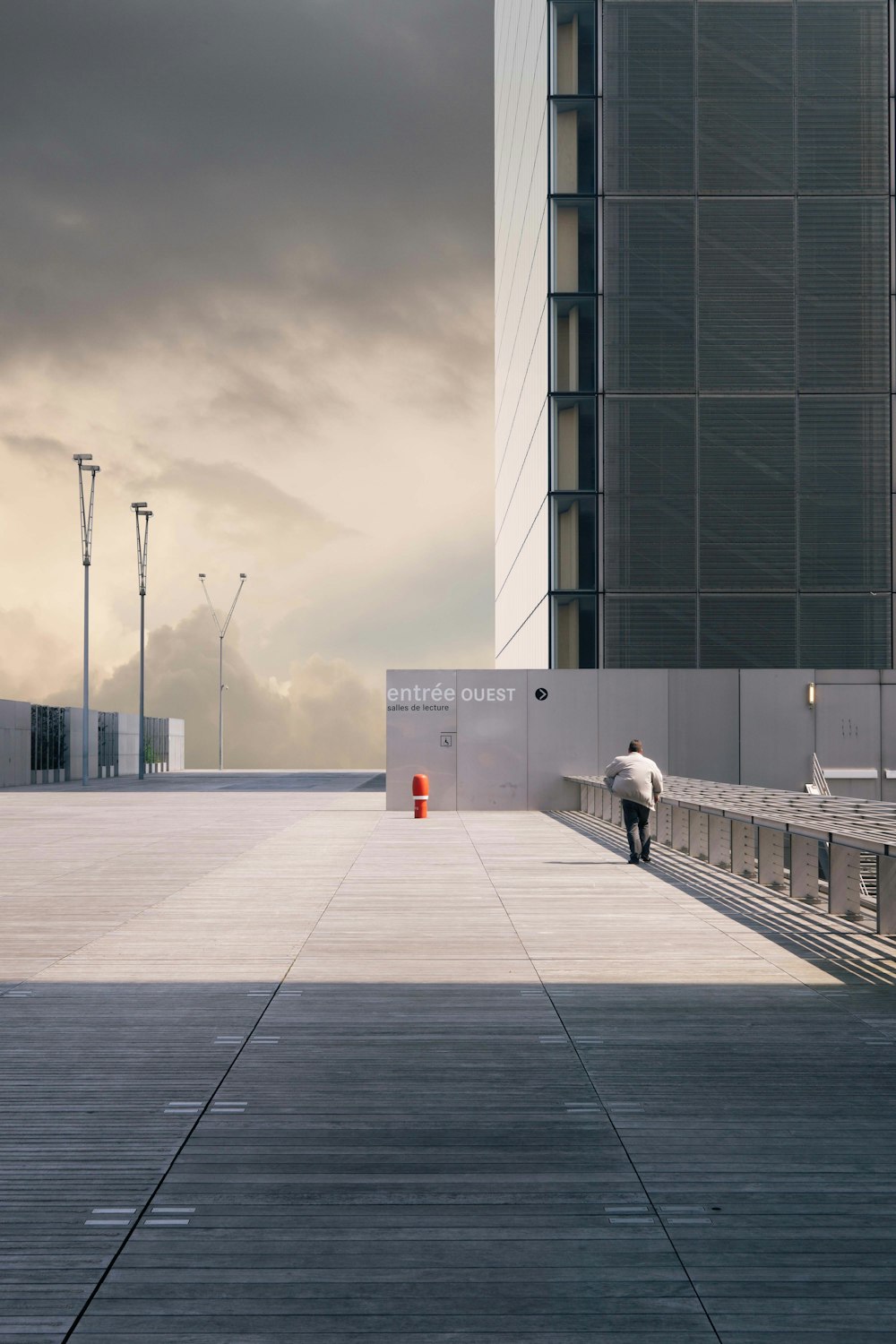 man walking on concrete pavement near building during daytime