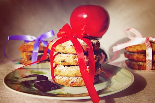 A stack of classic sugar cookies tied with a red ribbon, ready for gifting.