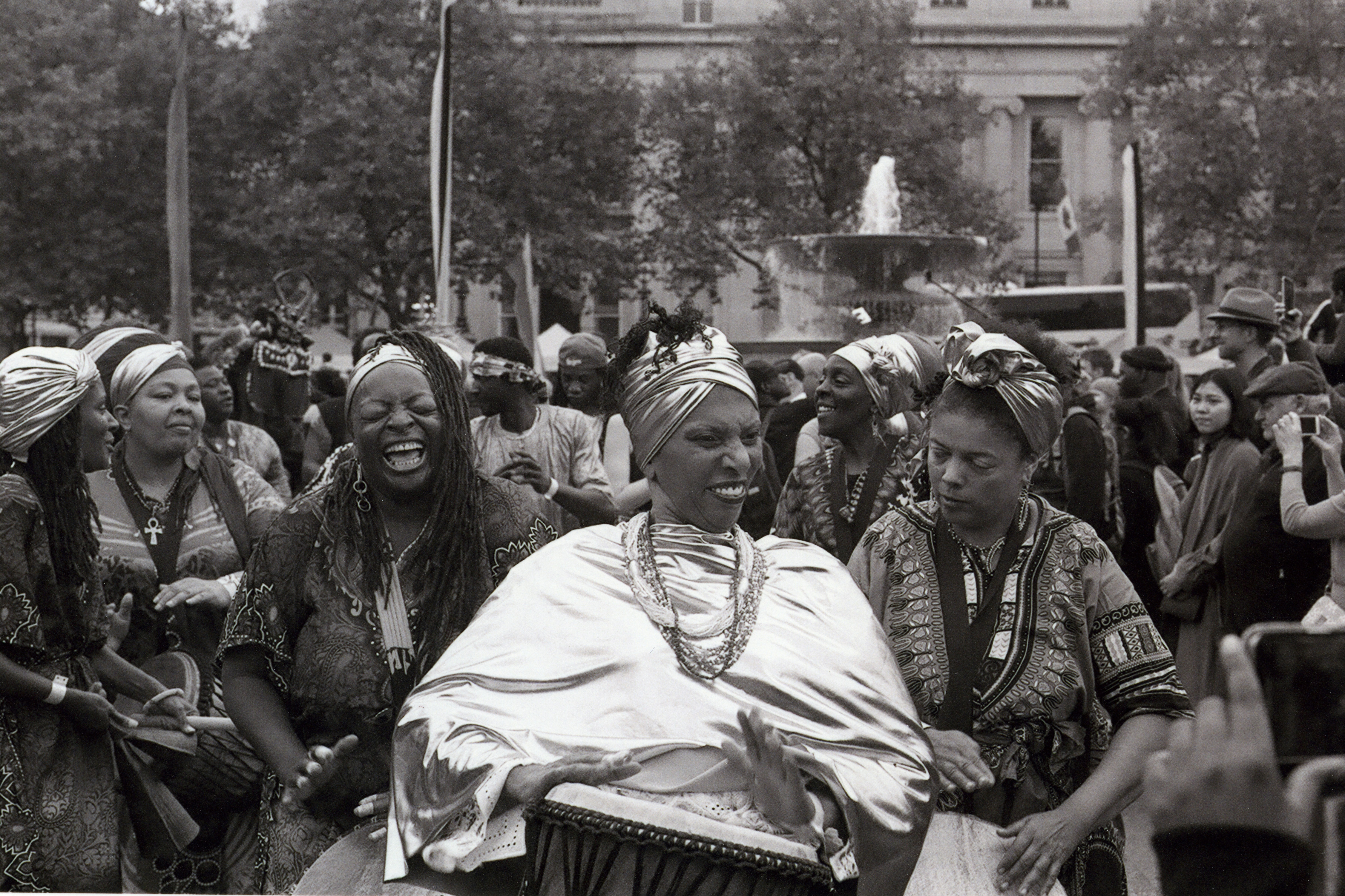 Group of African women laughing together outdoors in warm sunlight