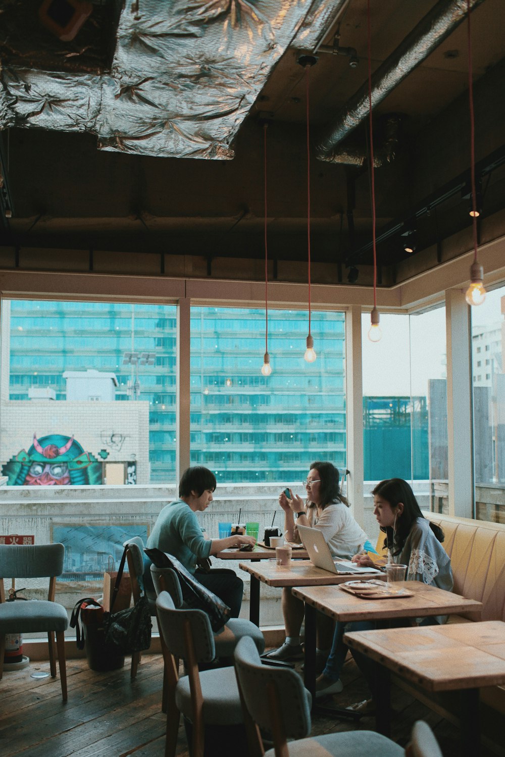 three persons sitting on chairs inside restaurant