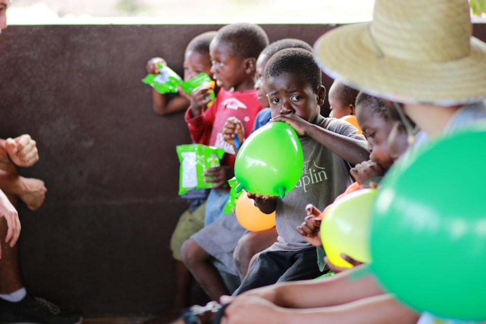 boy blowing green balloon