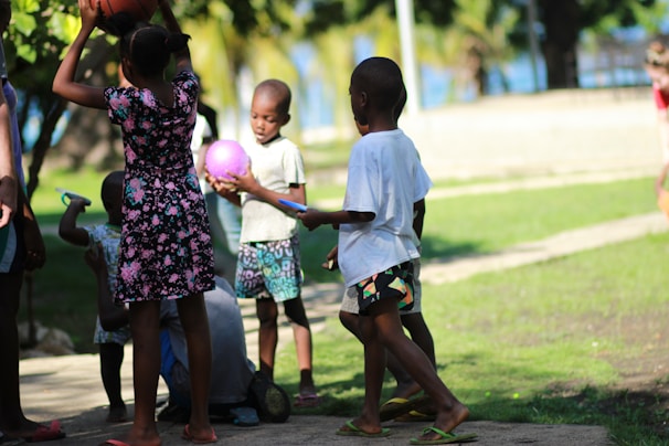 A group of kids in a playground, dribbling colorful basketballs designed for early education.