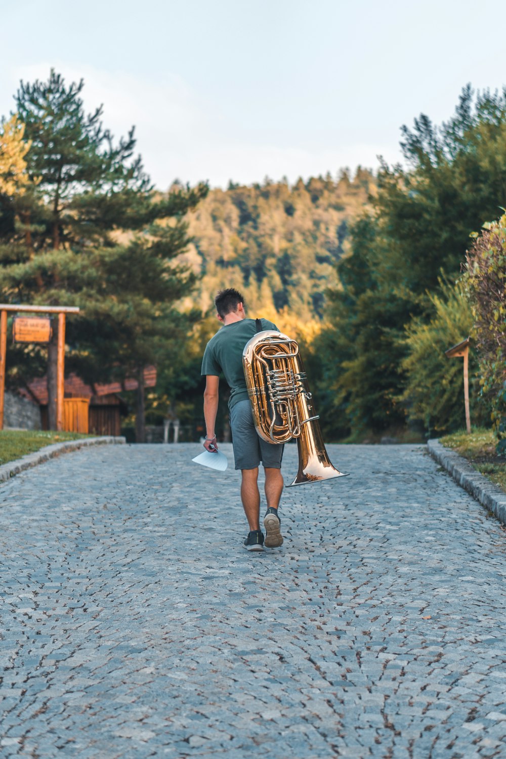 man carrying brass music instrument