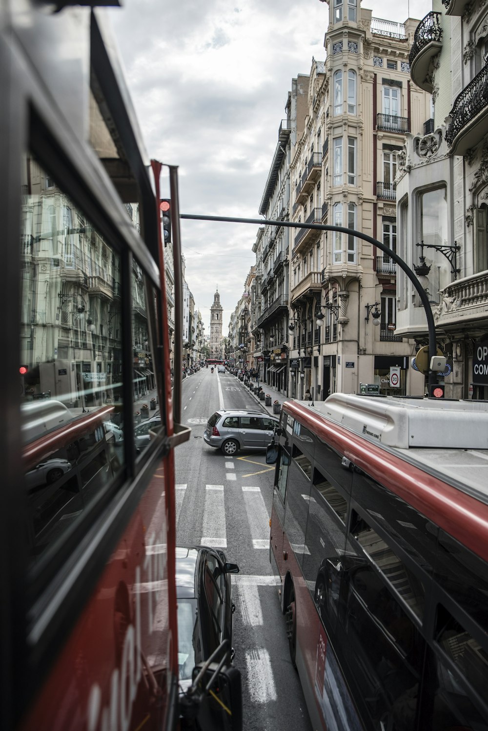 red double-deck bus beside red ordinary bus