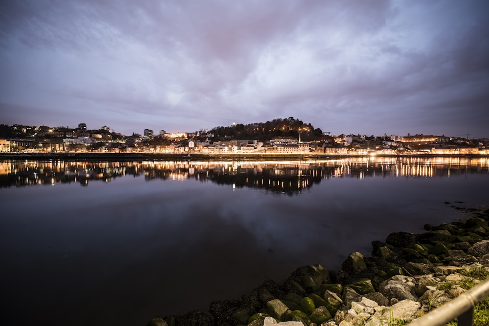 cityscape at night near body of water