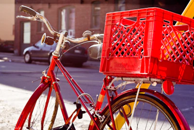 A sleek red tandem bicycle parked on a sunny street