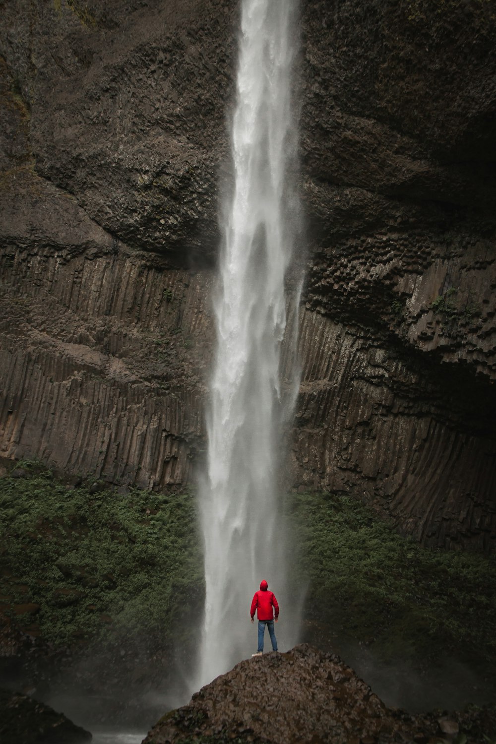 man standing near waterfalls