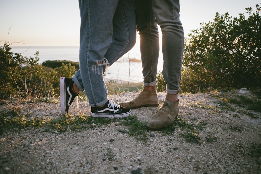 two persons standing on sand