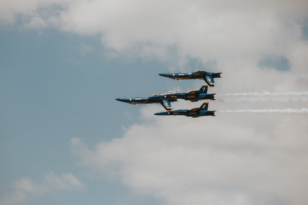 four blue jet planes living contrails under white sky during daytime