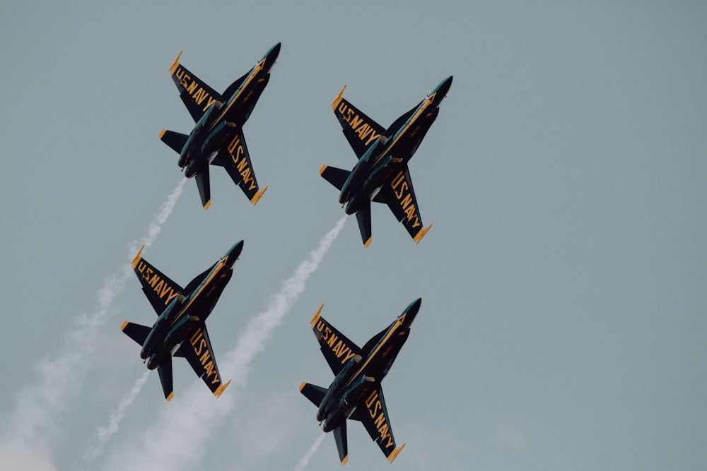 four black-and-yellow planes doing contrails