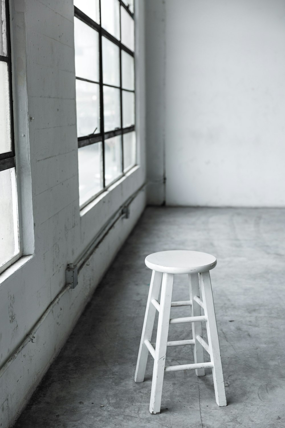 round white wooden stool near closed window
