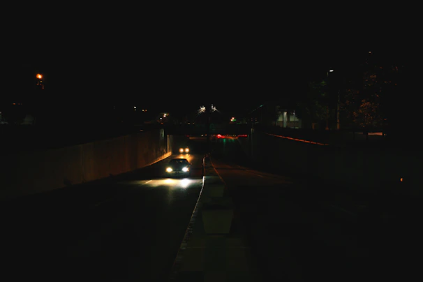 Projector headlights illuminating a dark road.
