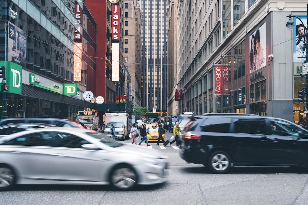 people walking on pedestrian lane near buildings and cars during daytime