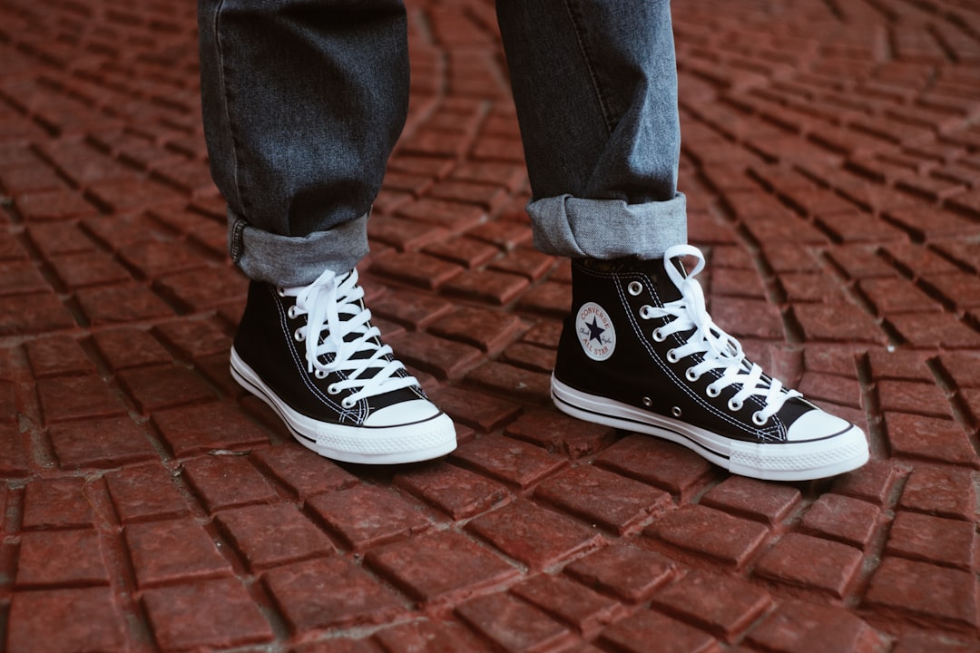 person showing pair of Converse All-Star high tops,