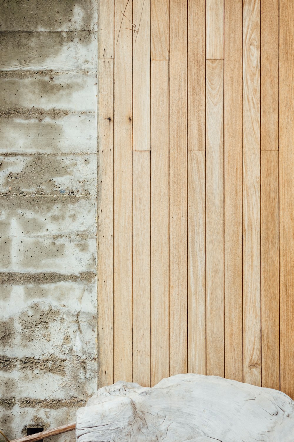 a white umbrella sitting in front of a wooden wall