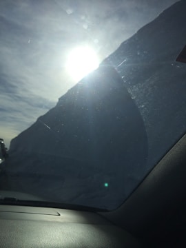 A freshly installed windshield shining under the sunlight on a vehicle outside Bayou Glass & Shield.