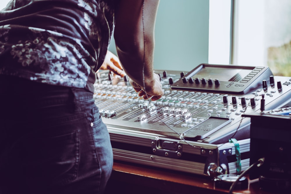 photo of person adjusting audio mixer