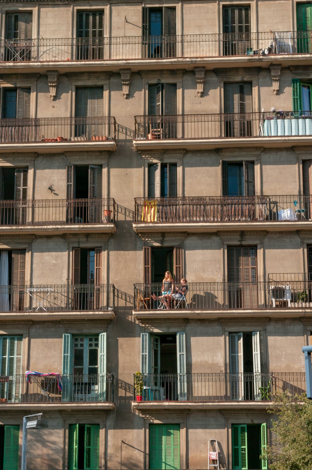 Dos hombres y mujeres en el balcón del edificio durante el día