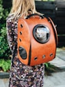 woman carrying pet carrier while standing near green plant