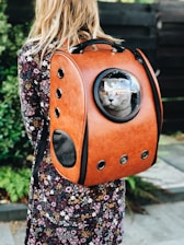 woman carrying pet carrier while standing near green plant