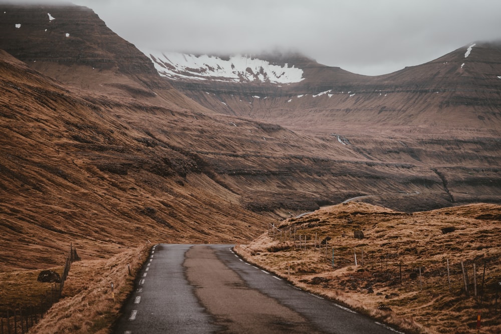 road in between brown mountains