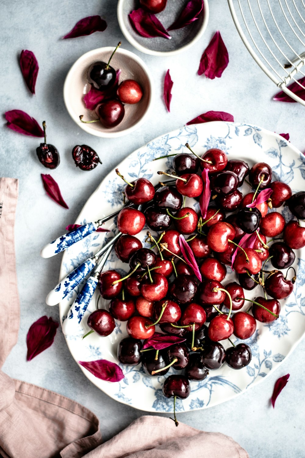 Frutos rojos de cereza en plato ovalado de cerámica floral blanca y azul